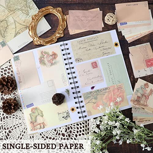 Vintage scrapbook with postcards, flowers, and decorative items.