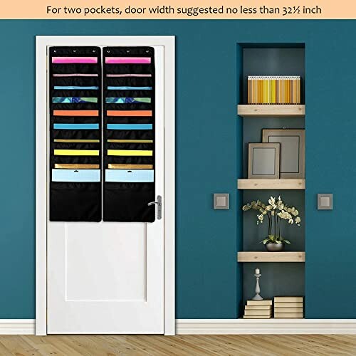 Over-the-door organizer with multiple pockets on a white door beside a shelf with books and decor.