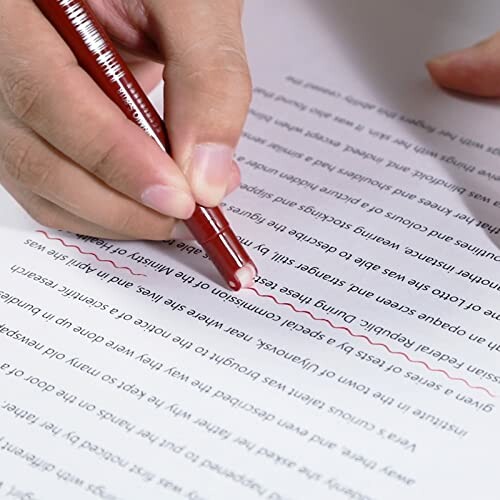 Hand editing a document with a red pen.