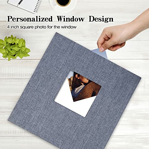 Hand inserting photo into gray square frame with window.