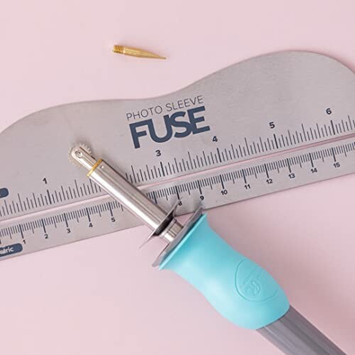 Photo Sleeve Fuse tool on pink background with ruler.